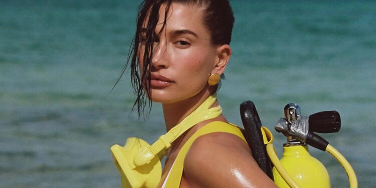 Hailey Bieber Flaunts Her Toned Physique in Chic Black Swimwear Accompanied by Bright Yellow Diving Equipment